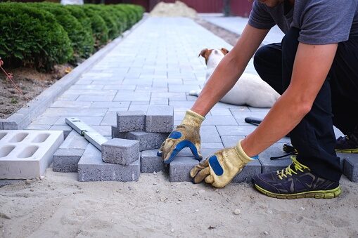 Workers building a stone walkway in a residential yard in Pelham, NH