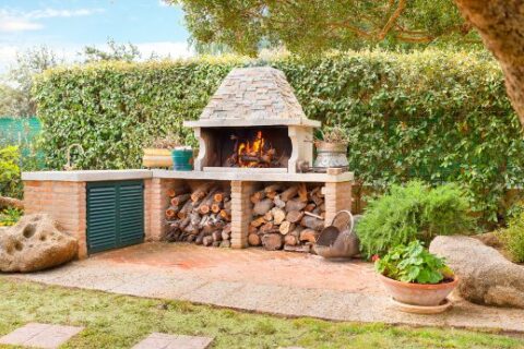 Impressive outdoor kitchen with a fireplace in a home in Pelham, NH