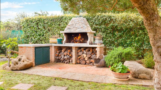 Impressive outdoor kitchen with a fireplace in a home in Pelham, NH